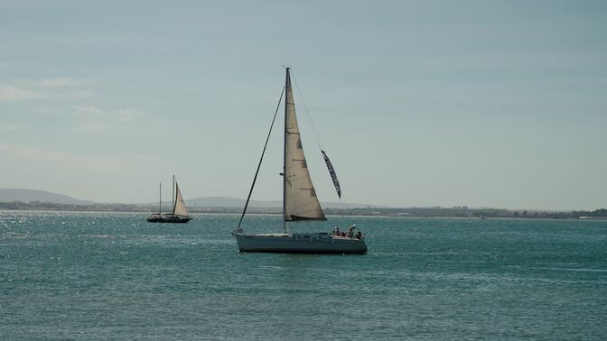 Sailboats Sailing On The Tagus River In Lisbon, Portugal   Wide Shot