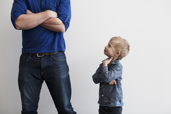 Son Looking Up At His Father With A Smirk. 